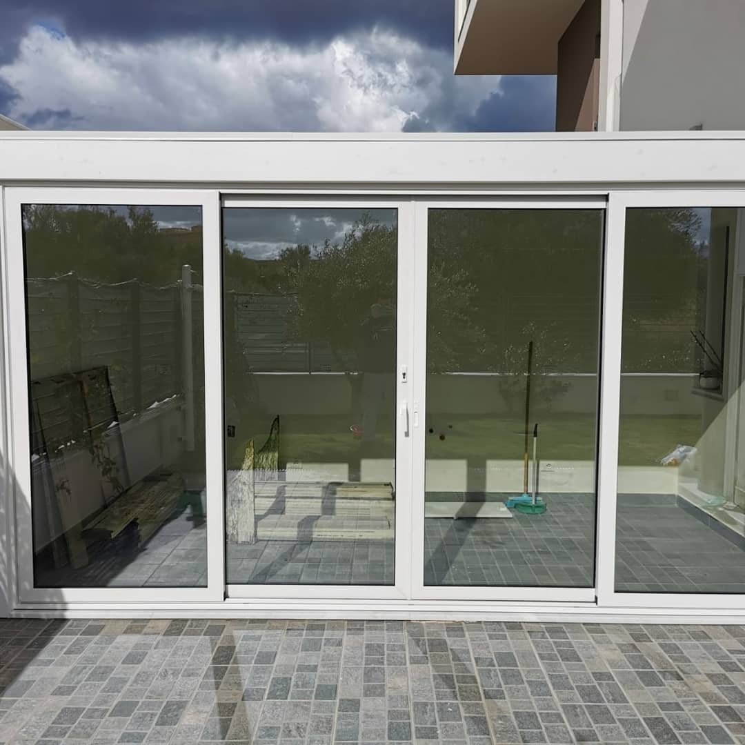 Scorrevole bianco a quattro ante che chiude un terrazzo