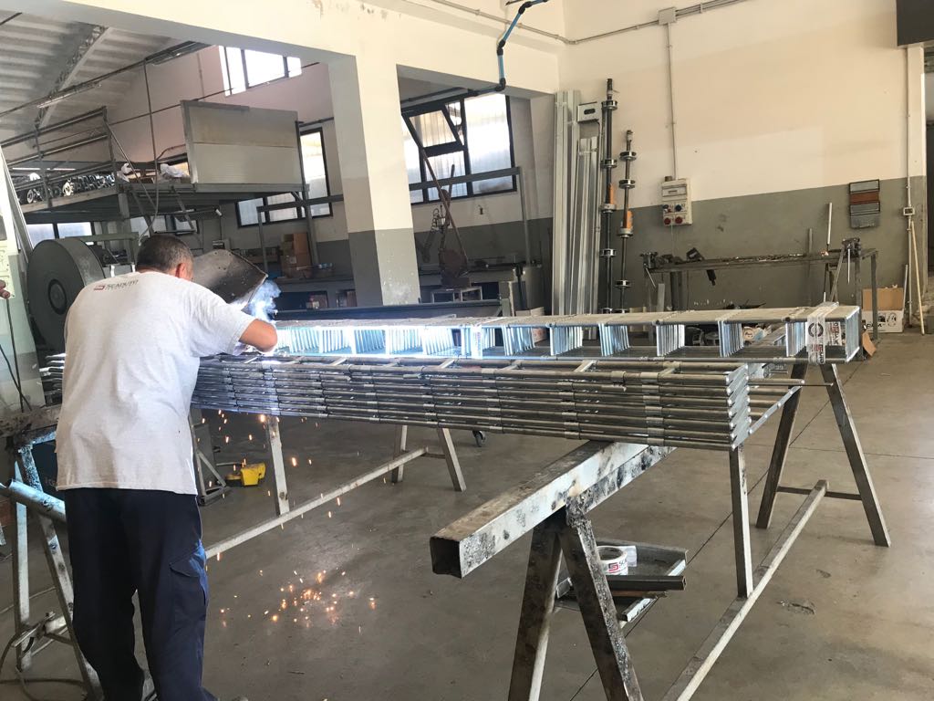 Operaio al lavoro su profili in ferro nello stabilimento
