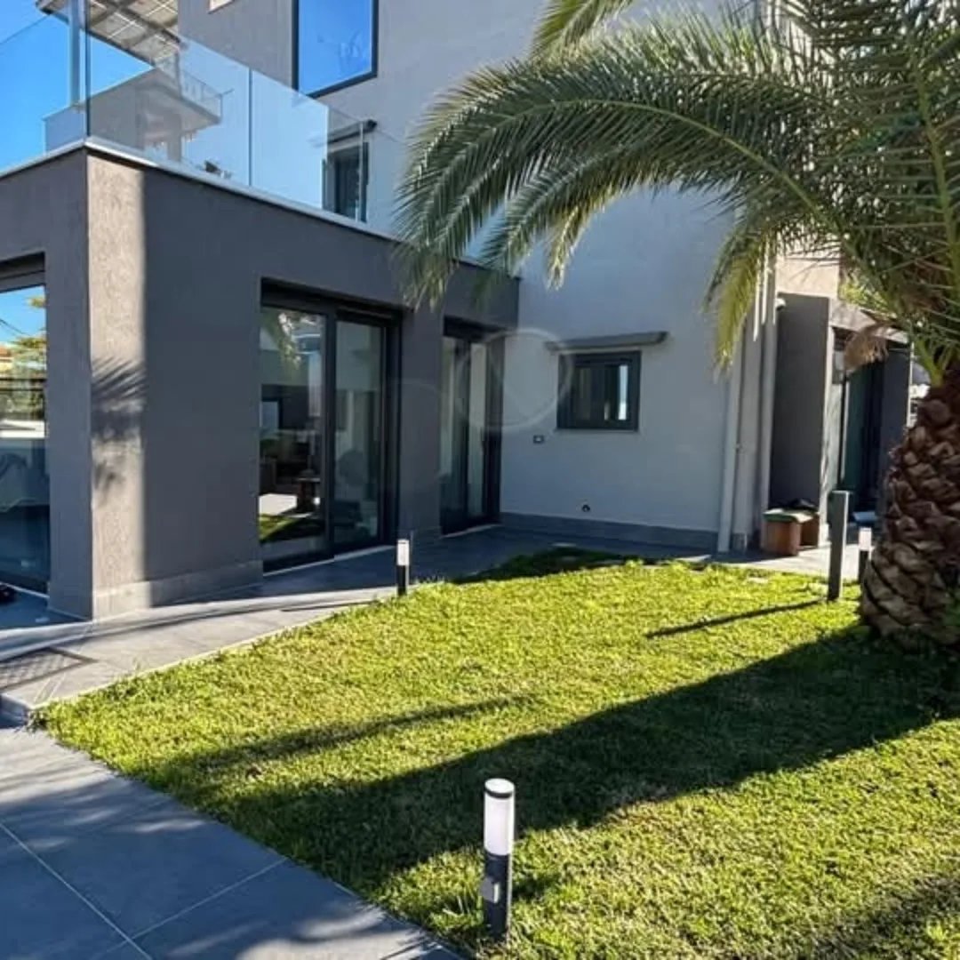 Villa moderna con vetrate scorrevoli in alluminio scuro sul giardino